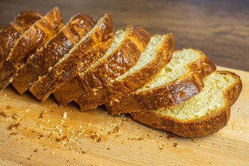 Slice Brioche toast loaf with bread crumbs on wood cutting board, bakery or breakfast concept.