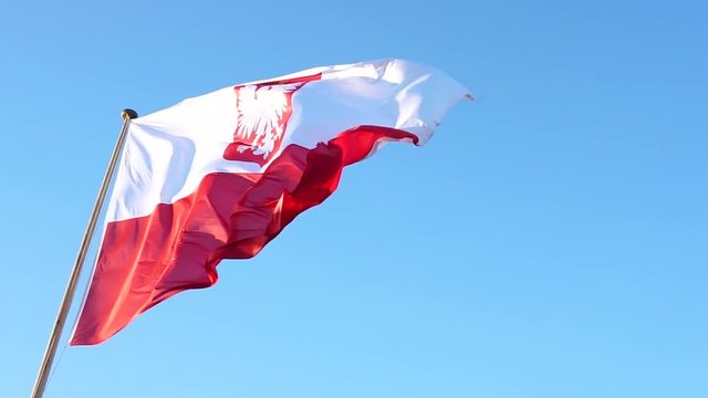 Slow motion. Flag of Poland. Big flag with empble on blue sky
