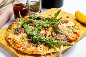 crispy pizza pamaham, mozzarella cheese, salmon w served with tomato sauce and herbs