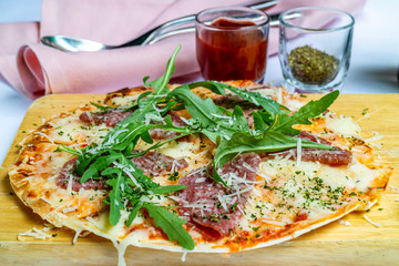 crispy pizza pamaham, mozzarella cheese, salmon w served with tomato sauce and herbs