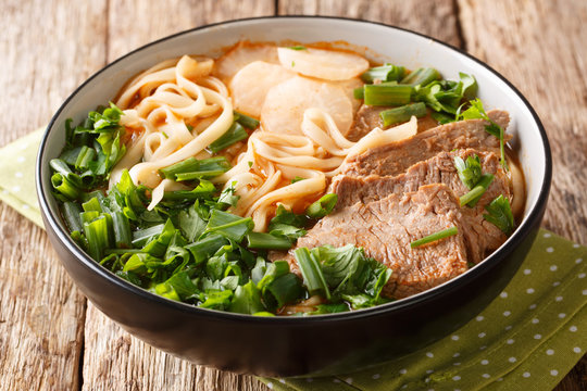Lanzhou beef noodle soup is a type of Chinese ramen noodle soup with beef slices served on the top closeup in a bowl. horizontal