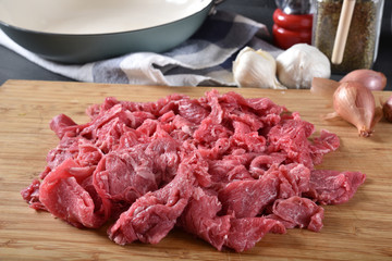 Raw shaved beef on a cutting board