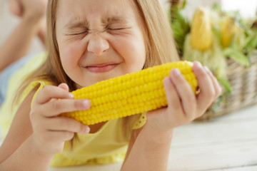 Child eating corn at home 