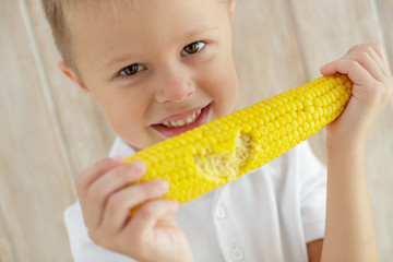 The child eats delicious corn at home 