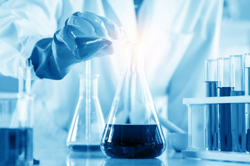 scientist with equipment and science experiments, laboratory glassware containing chemical liquid for research or analyzing a sample into test tube in laboratory