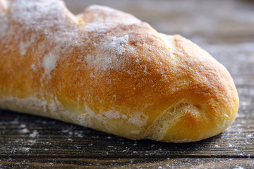 Fresh French loaf with a ruddy crust on a wooden table