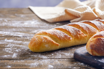 Fresh French loaf with a ruddy crust on a wooden table