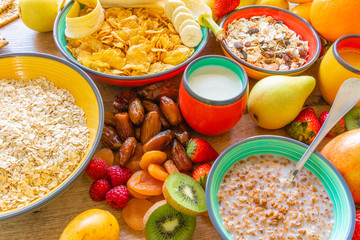 Top view of dried plums, strawberries, banana, cereals