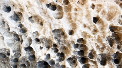 Texture of natural stone. Modern background. Image. Design for poster. Abstract backdrop. Black, grey, biege, sepia. Hole on the surface. Patterns and textures of rocks in nature. Closeup detail stone