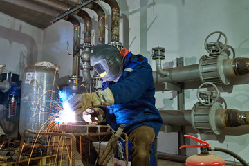Welder worker at industrial arc welding work