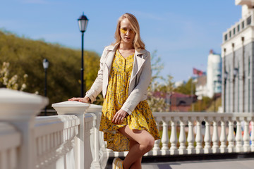 Beautiful blonde in a yellow dress on a Sunny day
