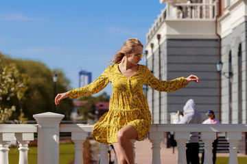 Beautiful blonde in a yellow dress on a Sunny day