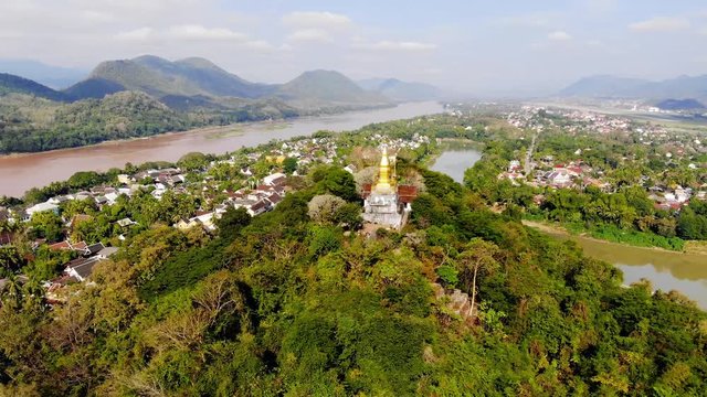 Panorama view of Luang Prabang Laos. top of Phou Si, the hill that dominates the city, popular location for sunrise sunset views. golden stupa on the top of Mount Phou Si. 4K move drone