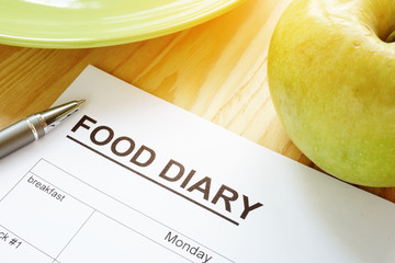 Food diary or meal plan and an apple.