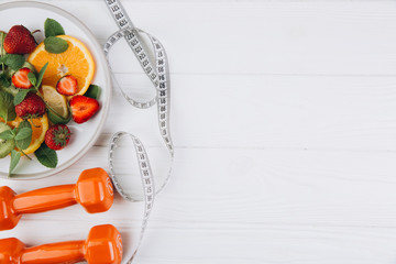 Naklejka na ściany i meble Diet plan, menu or program, tape measure, water, dumbbells and diet food of fresh fruits on white background, weight loss and detox concept, top view