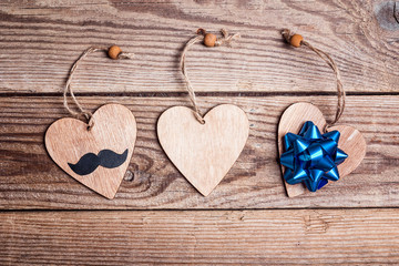 Fathers day concept with hearts, mustache and bow on old wooden table.