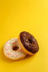 two black and white donuts on yellow background