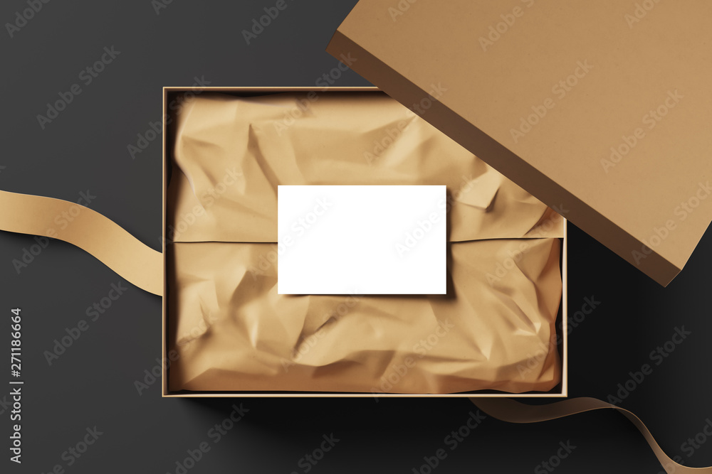 Poster realistic open cardboard box with wrapping paper, white business card and fabric ribbon on a black b