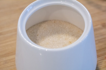 A closeup into a jar of turbinado sugar
