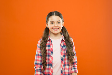 Upbringing versatile personality. Wellbeing and health. Childhood concept. Girl child stand orange background. Happy childhood. Grow mentally and physically healthy child. Child care and psychology