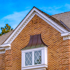 Square frame Luxurious exterior of a house with lush trees and serene sky background