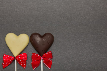 Chocolate candy in the form of hearts on a dark background. Background to Valentine's Day.