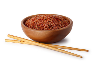 A wooden bowl with red rice and food chopsticks. Natural products, healthy food.