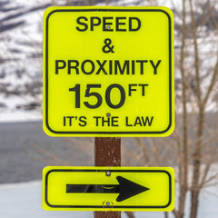 Square frame Close up of a bright yellow Speed and Proximity road sign with arrow
