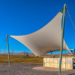 Square frame Concrete rectangular structure under a white canopy viewed on a sunny day