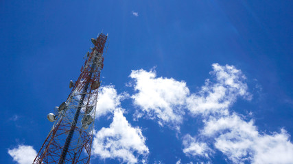 Telecommunication tower mast TV antennas, cellular wireless technology with blue sky background.
