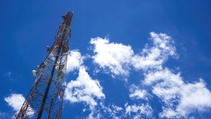 Telecommunication tower mast TV antennas, cellular wireless technology with blue sky background.