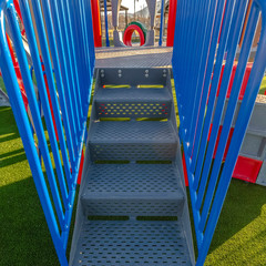 Square frame Stairs going up a slide overlooking mountain and bright sky on a sunny day