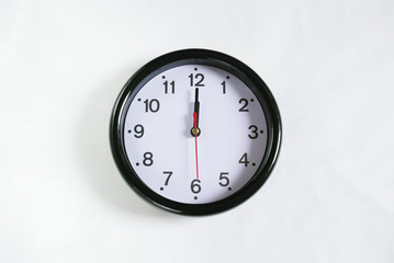 白い壁に掛かった12時の時計