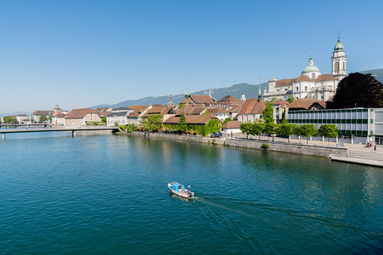  city of Solothurn with the river Aare panorama cityscape view of the old town and a fishing boat heading upstream
