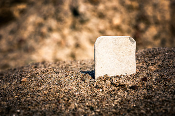 Clear printing board for logo or text branding. Clean stone nameplate in the sea sand.