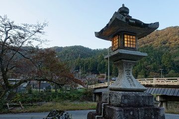 滋賀県の多賀町にある調宮神社の石灯籠と里山の風景