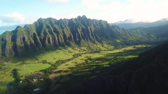 A panning drone shot revealing the Kualoa Mountain Range and Kualoa Park.
