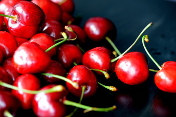 Ripe sweet cherry berries with water drops on a dark background close up