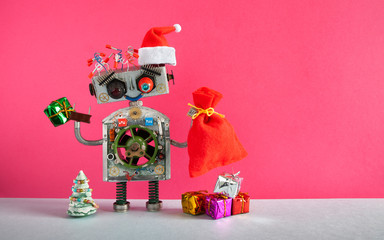 Happy Christmas Santa Claus robot with a bag of gifts and boxes, toy Xmas pine tree on pink...