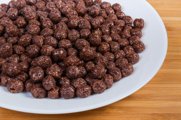 Breakfast cereal chocolate balls on dish close-up