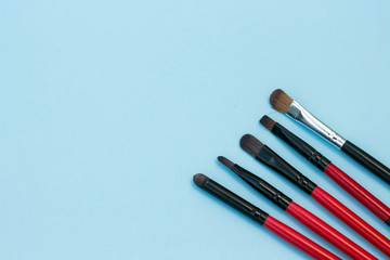 make up brushes blue background copy space