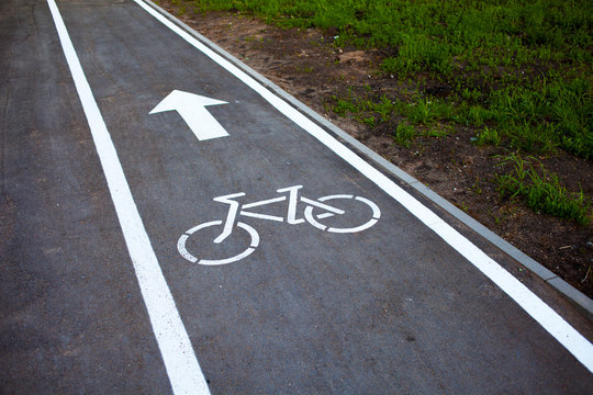 Bike path. Sign white paint on the pavement. Summer