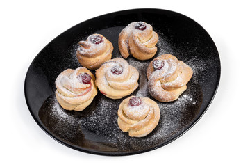 Baked sweet rolls with jam on the black dish