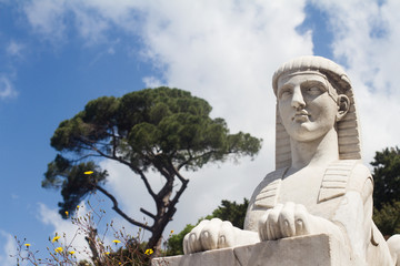 white marble sphynx statue in outdoor setting