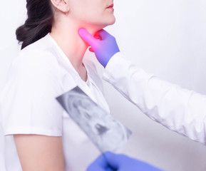 A specialist doctor diagnoses a girl s sore throat by palpating for the presence of inflammation...