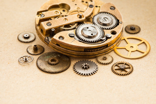 Ancient pocket watch clock chronometr mechanism with cogwheels cogs gears on paper background. close-up selective focus