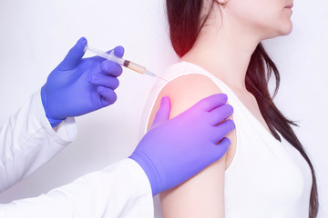 A doctor makes plasma-lifting injections to a patient who has pain and inflammation in the shoulder joint, arthrosis, close-up