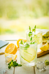 Summer lemonade in glasses in front of window, copy space