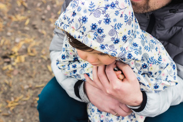 Father and daughter wearing coats and hoods spend quality time outdoors. Family and fatherhood concept