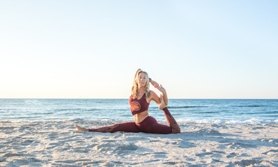 caucasian healthy adult woman with beautiful body doing yoga at sunrise on the beach, yoga poses